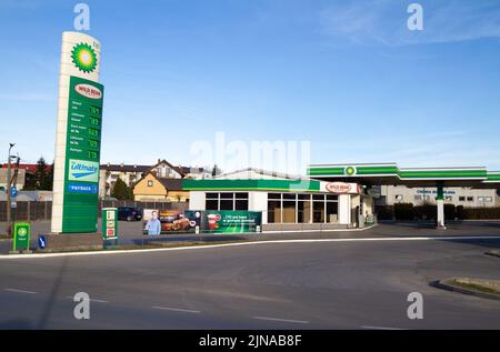 BP and Wild Bean Cafe sign outside a petrol station. British Petroleum logo at filling gas station forecourt with prices displayed on a pylon. Stock Photo