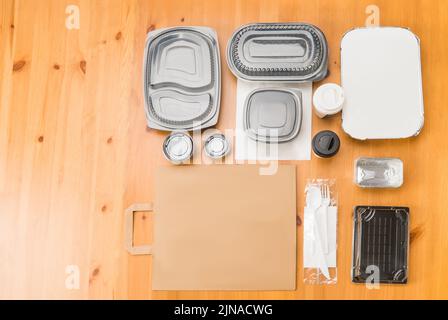 Empty cardboard and plastic fast food takeaway containers on wooden table. Stock Photo