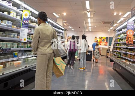 Rear view of woman shopper M&S interior Marks and Spencer food hall store looking at dairy & plant based products UK Great Britain 2022   KATHY DEWITT Stock Photo