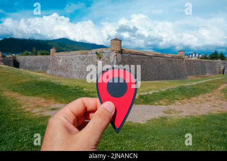 closeup of the hand of a man holding a red marker pointing the Citadel of Jaca, in Jaca, in the province of Huesca, Aragon, Spain, in a sunny summer d Stock Photo