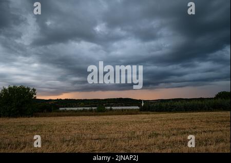Dramatic cloudy skies as a twilight thunderstorm sweeps over the Romanian countryside Stock Photo