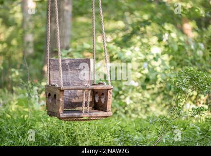 Old Wooden and rope chair swing Stock Photo
