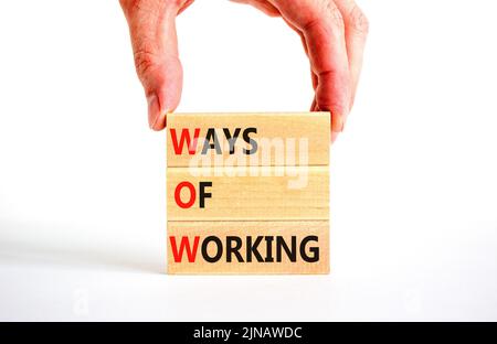 WOW ways of working symbol. Concept words WOW ways of working on wooden blocks on a beautiful white table white background. Businessman hand. Business Stock Photo