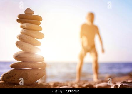 beach pebble stones pyramid on sunset sea shore Stock Photo