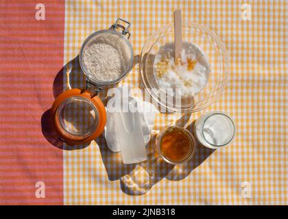 Homemade rice face mask recipe. Fermented rice broth, rice water, honey, milk mixed in the bowl. Stock Photo