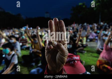 Pathum Thani, Thailand. 10th Aug, 2022. Demonstrators make three finger salute during the demonstration. Pro-democracy demonstrators gathered at Thammasat University, Rangsit Campus in Pathum Thani where they first mentioned about the monarchy reformation 2 years ago. Demonstrators demand the resignation of Thailand's prime minister, Prayuth Chan-ocha, and reforms to the monarchy. Credit: SOPA Images Limited/Alamy Live News Stock Photo