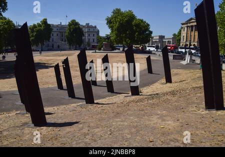 Parched and scorched grass is seen around the New Zealand War Memorial in Hyde Park Corner as heatwaves and drought caused by climate change continue in the UK. Stock Photo