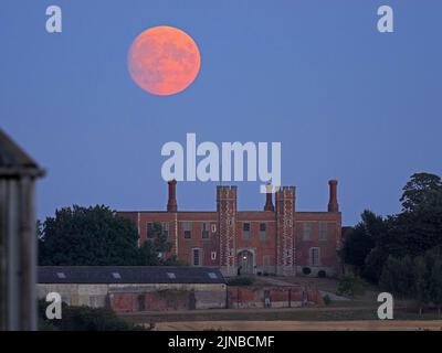 Eastchurch, Kent, UK. 10th Aug, 2022. UK Weather: the nearly full Sturgeon moon - the last supermoon of 2022 - seen rising above historic Shurland Hall gatehouse in Eastchurch, Kent. Credit: James Bell/Alamy Live News Stock Photo