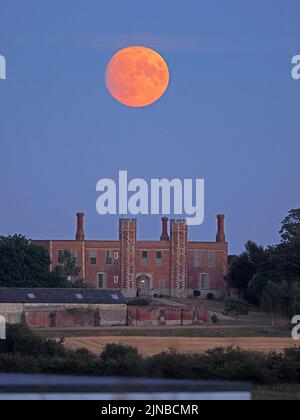 Eastchurch, Kent, UK. 10th Aug, 2022. UK Weather: the nearly full Sturgeon moon - the last supermoon of 2022 - seen rising above historic Shurland Hall gatehouse in Eastchurch, Kent. Credit: James Bell/Alamy Live News Stock Photo