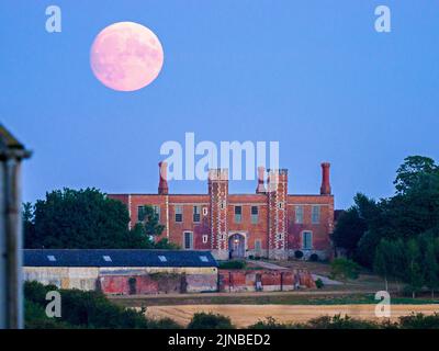 Eastchurch, Kent, UK. 10th Aug, 2022. UK Weather: the nearly full Sturgeon moon - the last supermoon of 2022 - seen rising above historic Shurland Hall gatehouse in Eastchurch, Kent. Credit: James Bell/Alamy Live News Stock Photo