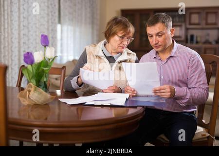 Man with elderly mother discussing documents Stock Photo