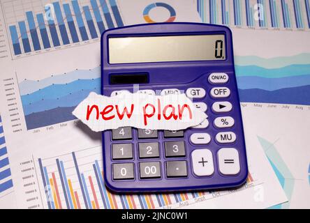 Text New Plan on white paper notepad with cup of coffee and pen on light background. Business concept. Shadow Stock Photo