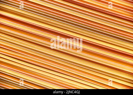 Abstract italian food background, raw colourful vegetable spaghetti filling the frame in a textured design of mixed colors diagonal pasta lines. Stock Photo