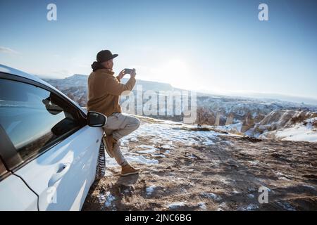 man using his phone to take the photo of beautiful scenery in cappadocia Stock Photo