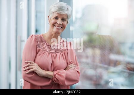 The journey you have taken to get where you are. Portrait of a cheerful mature businesswoman posing with her arms folded in her office at work. Stock Photo