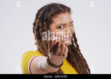 No no no senior, bring it back here. Portrait of a beautiful young woman pointing to the camera against a grey background. Stock Photo