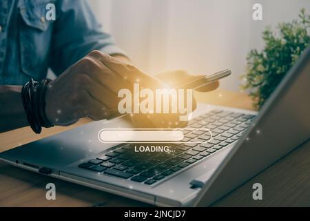 Casual Businessman Touching Mobile Phone or Smart Phone and Loading Bar and Laptop Computer. Searching or Downloading Concept in Vintage Tone Stock Photo