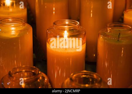 Orange Votive candles inside church. Stock Photo