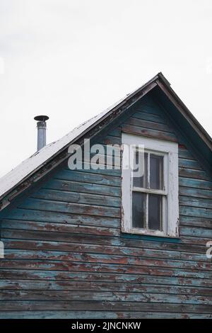 Partial view of an old abandoned two story house with upstairs window. Stock Photo