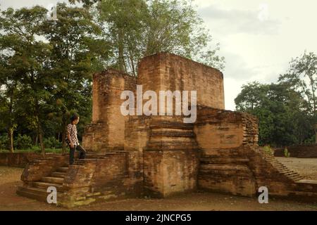 A villager is posing for a photo at Gedong I temple in Muara Jambi temple compounds in Muaro Jambi, Jambi, Indonesia. Stock Photo