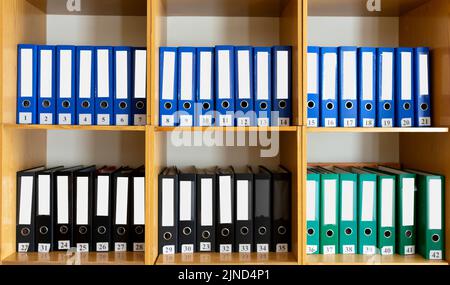 A bookshelf with many different folders on it. There are many different folders on the bookshelf at school. Stock Photo
