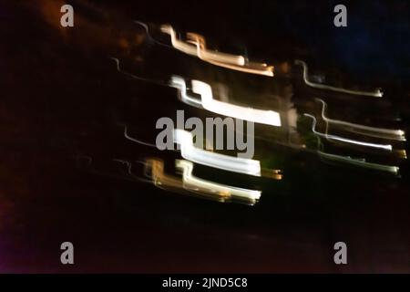 Close up shot of Several different colored lines moving in the dark. Camera movement. Stock Photo