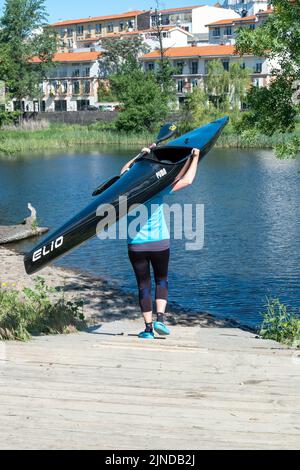 Plasencia, Spain - April 17, 2021: A young man practices canoeing riding in his canoe navigating the Jerte river Stock Photo