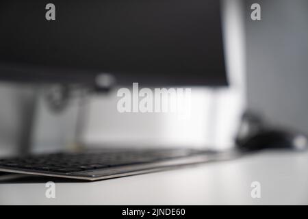 A selective focus shot of a keyboard and computer in the background Stock Photo