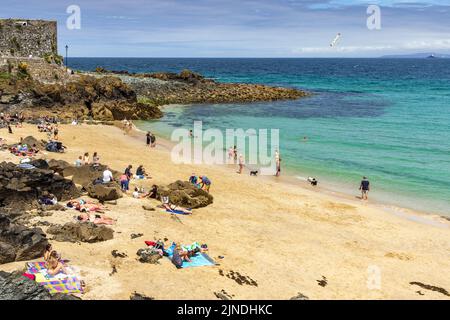 People enjoying a sunny summer's day at Bamaluz Beach in St Ives, Cornwall, England. Stock Photo