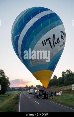 Heldburg, Germany. 11th Aug, 2022. A hot air balloon is prepared for takeoff for the 1st flight of the German Hot Air Ballooning Championship. The 25th Thuringian Montgolfiade, the German Hot Air Ballooning Championship, takes place for the first time in Heldburg. Of the 58 hot air balloons registered, 33 will take part in the competition. The organizer is the Ballonsportclub Thüringen. The Montgolfiade offers a hiking program on the weekeine together with the tourism association Coburg-Rennsteig. Credit: Daniel Vogl/dpa/Alamy Live News Stock Photo