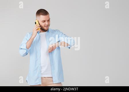 Handsome young man using cell phone while standing Stock Photo