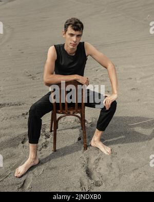 Lone Man sitting on chair in desert Stock Photo