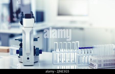 Closeup of microscope, test tubes and pipettes or droppers in medical, science or chemistry laboratory. Empty glass vials for monkeypox, ebola or Stock Photo