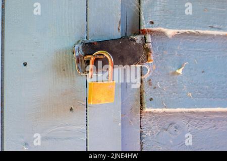 Open padlock on garden shed door leaving shed unlocked vulnerable to robbery Stock Photo