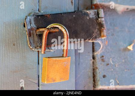 Open padlock on garden shed door leaving shed unlocked vulnerable to robbery Stock Photo