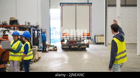Multiethnic engineers working inside robotic factory - Focus on right man back Stock Photo