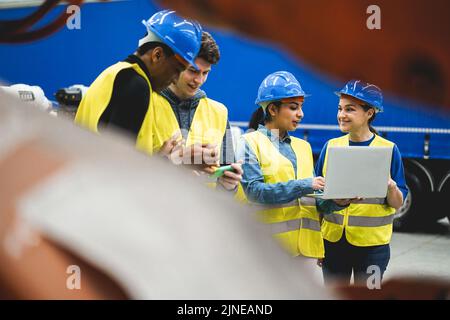 Multiethnic engineers working inside robotic factory - Focus on senior woman helmet Stock Photo