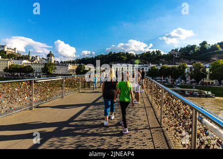 people walking over the Makartsteg bridge, which is covered in love locks over the Salzach River, Salzburg, Salzburg State, Austria, Europe Stock Photo