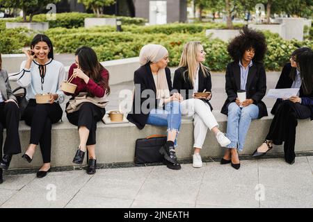 Multiethnic business women doing lunch break outdoor from office building - Main focus on indian girl face Stock Photo