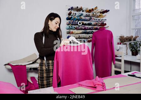 Seamstress working with sewing pattern on table in tailor shop Stock Photo