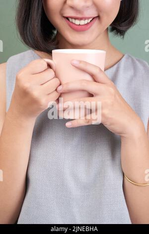 Cropped image of smiling woman having big mug of coffee Stock Photo