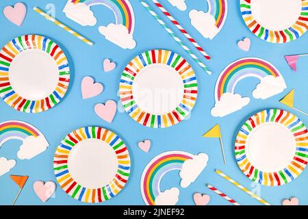 Party flat lay with colorful plates, rainbow napkins and drinking straws on blue background Stock Photo