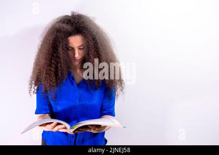 Afro-haired young girl studying a book of sheet music Stock Photo