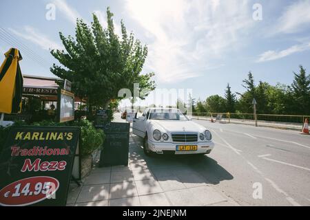 Paphos, Cyprus - Oct 29, 2014: Karlina's Traditional Meze with price of 14,95 euros signage near the restaurant with luxury Mercedes-Benz E Klass parked nearby Stock Photo