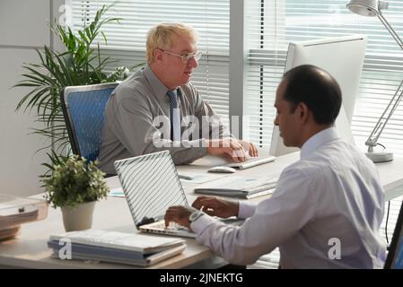 Business executives working on computers in modern office Stock Photo