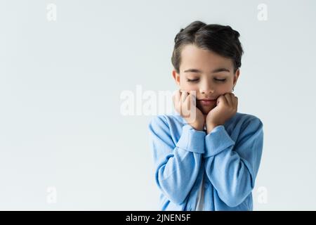 frustrated girl with closed eyes holding hands near face isolated on grey, banner,stock image Stock Photo