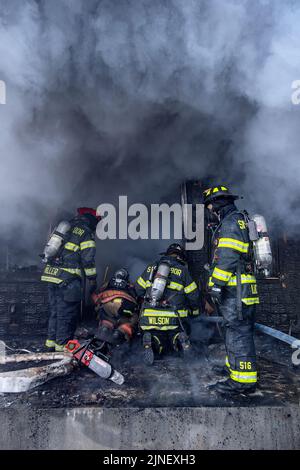 Residence and firefighters work to extinguish a fire that broke out in ...