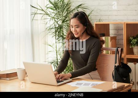 Pretty female technical support operator answering e-mails Stock Photo