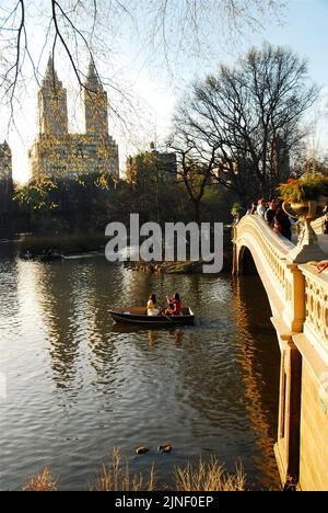 People enjoy renting a rowboat and rowing on the lake near the Bow bridge in New York City's Central Park on a warm early spring day Stock Photo
