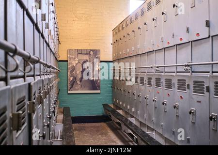 The silver metal lockers, used by the miners for a change of street clothes. At the Big Pit National Coal Museum in Pontypool, Wales, United Kingdom. Stock Photo